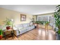 Bright living room with wood floors, a comfortable couch, and a bay window with plants at 6851 Roswell Rd # B15, Sandy Springs, GA 30328