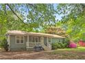 Exterior of a charming single story home with a metal roof, a front porch, and a well-maintained lawn at 928 Rocky Creek Rd, Hampton, GA 30228
