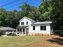 Stylish two-story home boasts white siding, black-framed windows, and freshly landscaped front yard on a sunny day at 169 Long Dr, Marietta, GA 30060
