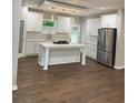 Spacious kitchen with white cabinets, a central island with a gas cooktop, and stainless steel refrigerator at 169 Long Dr, Marietta, GA 30060