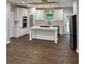 Bright kitchen featuring white cabinets, a large island, stainless steel appliances, and elegant pendant lighting at 169 Long Dr, Marietta, GA 30060
