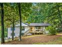 Inviting white home with black trim features a cozy front porch and wooded views at 2152 Tourney Dr, Marietta, GA 30062