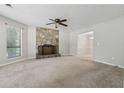 Bright living room with a stone fireplace, large windows, and neutral carpet at 706 Cather Ct, Stone Mountain, GA 30088