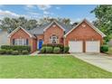 Beautiful brick home with a well-kept lawn, blue front door, and two-car garage at 4512 Evan Ct, Hoschton, GA 30548