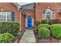 Inviting entryway with a bright blue door and lush, manicured landscaping at 4512 Evan Ct, Hoschton, GA 30548