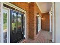 Close-up of the inviting brick porch with a glass front door, white trim, and brick accents at 5030 Princeton Trce, Cumming, GA 30041