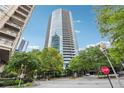 Striking exterior view of a modern high-rise building with a sleek glass facade and lush landscaping at 3338 Peachtree Rd # 1210, Atlanta, GA 30326