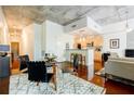 Open-concept living and dining area with modern decor and exposed concrete ceiling at 335 W Ponce De Leon Ave # 308, Decatur, GA 30030