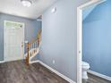 Welcoming entryway with wood-look flooring, staircase, and convenient access to a half bathroom at 3366 Thornbridge Dr, Powder Springs, GA 30127