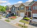 Street view of lovely townhomes featuring lush landscaping, garages and well-maintained lawns at 3366 Thornbridge Dr, Powder Springs, GA 30127