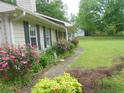 Charming pathway lined with colorful roses and lush greenery enhance curb appeal at 770 Starrsville Rd, Covington, GA 30014