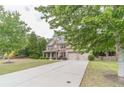 Well-maintained two-story brick home features an attached two-car garage and long driveway at 882 Nestling Dr, Lawrenceville, GA 30045