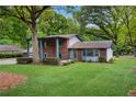 Traditional-style home with mature landscaping and a large green lawn at 1055 Heather Ct, Lawrenceville, GA 30043