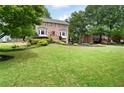 Spacious front lawn with a beautiful brick home, mature trees, and colorful landscaping at 1470 Rhododendron Nw Dr, Acworth, GA 30102