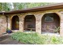 Inviting brick archway leading to front porch with seating area and well-kept landscaping at 2425 Maclaren Cir, Dunwoody, GA 30360