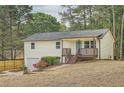 Charming home with a covered front porch, steps, and an inviting blue door nestled amongst mature trees at 1213 Anderson Mill Rd, Austell, GA 30106