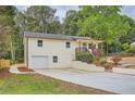 Charming house with an attached garage, covered porch, concrete driveway, and a blue front door at 1213 Anderson Mill Rd, Austell, GA 30106