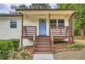 Up close front porch with wood detail, blue door and rose bush at 1213 Anderson Mill Rd, Austell, GA 30106