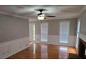 Spacious living room with hardwood floors, a fireplace, and natural light from multiple windows at 1511 Harbor Watch Ct, Woodstock, GA 30189