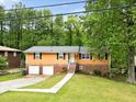 Charming home featuring brick accents, a two-car garage, and a welcoming entrance in a lush, green setting at 1563 Greenwood Dr, Norcross, GA 30093