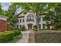 Elegant two-story home with a stone facade, manicured landscaping, and a charming balcony above the front door at 3127 Lenox Ne Rd # 1, Atlanta, GA 30324