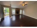 Cozy living room featuring stone fireplace and hardwood floors at 1231 Providence Way, Lawrenceville, GA 30046