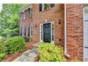 Close-up of a home's brick facade and front door, showing the landscaped entryway at 5574 Wynhall Dr, Peachtree Corners, GA 30071