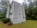 A side view of a two-story home featuring modern gray siding, trimmed windows and a chimney at 5769 Shadow Creek Dr, Lithonia, GA 30058