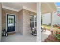 Inviting front porch with rocking chairs, brick accents, and a charming entrance door at 461 Timberleaf Rd, Canton, GA 30115