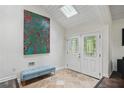 Welcoming foyer featuring tiled flooring, a comfortable bench, and a decorative front door at 495 Ramsdale Dr, Roswell, GA 30075