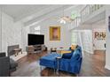 Comfortable living room featuring vaulted ceilings, brick fireplace, hardwood floors, and blue sofa at 495 Ramsdale Dr, Roswell, GA 30075