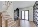 Elegant staircase featuring wood stairs, glass railings, and modern wall accents at 51 Deer Canyon Dr, Auburn, GA 30011