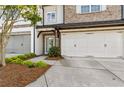 Charming townhome featuring an attached two-car garage and meticulously maintained landscaping at 565 Stone Field Nw Run, Marietta, GA 30060