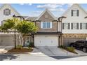 Beautiful townhome showcasing a brick facade, an attached two-car garage, and lush green landscaping at 565 Stone Field Nw Run, Marietta, GA 30060