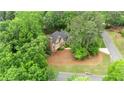Aerial view of a traditional home with mature trees and a circular driveway at 1100 Kensington Ct, Johns Creek, GA 30022