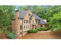 Elegant brick home with a well-maintained lawn and mature trees offers great curb appeal at 1100 Kensington Ct, Johns Creek, GA 30022