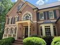 Charming brick home with classic architectural details and lush landscaping at 1100 Kensington Ct, Johns Creek, GA 30022