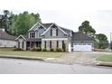 Two-story home featuring stone and siding, well-maintained lawn, two-car garage and extra parking on a concrete driveway at 15 Worthington Dr, Villa Rica, GA 30180