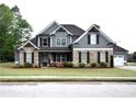 Beautiful two-story home featuring stone and siding, complemented by a lush front lawn and an attached two-car garage at 15 Worthington Dr, Villa Rica, GA 30180
