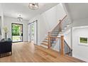 Bright foyer with hardwood floors, modern staircase, a black accent cabinet, and steel-framed glass door at 340 Colewood Way, Atlanta, GA 30328