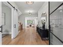 Bright foyer with hardwood floors, a modern light fixture, an accent mirror, and sliding barn doors at 340 Colewood Way, Atlanta, GA 30328