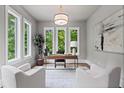 Sunlit home office with three large windows, neutral walls, modern lighting, and cozy white chairs at 340 Colewood Way, Atlanta, GA 30328