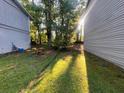 Sunlight in the yard of this home with green grass and wooded perimeter at 3948 Valley Brook Rd, Snellville, GA 30039