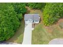 Aerial view of a home with a long driveway surrounded by mature trees at 401 Farm Brook Ln, Dallas, GA 30157