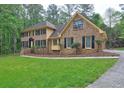 Beautiful home featuring a lush green lawn and a brick exterior with dark shutters at 5621 Wildwood Trl, Lithonia, GA 30038