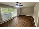 Bright living room featuring wood flooring, a ceiling fan, and a large window at 1263 Shoreham Dr, Atlanta, GA 30349