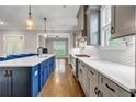 Modern kitchen features white quartz countertops, a stylish blue island, and stainless steel appliances for a sleek design at 6351 Granbury Nw Walk, Acworth, GA 30101