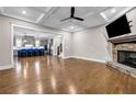 Open concept living room featuring hardwood floors, a stone fireplace, and seamless kitchen access; ideal for entertaining at 6351 Granbury Nw Walk, Acworth, GA 30101