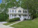 Lovely two-story home with a welcoming front porch, complemented by mature trees and well-manicured landscaping at 405 Sable Trace Cv, Acworth, GA 30102