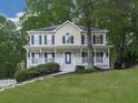 Inviting two-story home with a classic front porch, white railings, and a lush green lawn at 405 Sable Trace Cv, Acworth, GA 30102